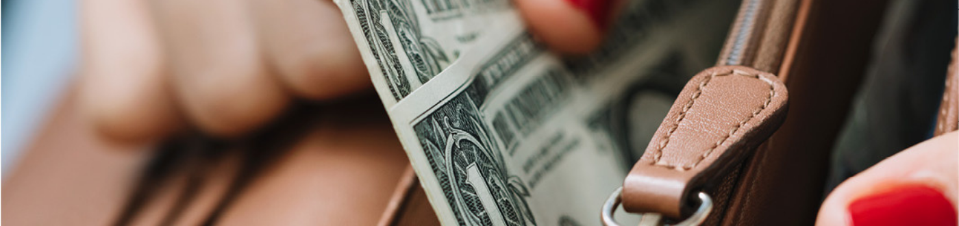 person pulling cash out of their wallet 