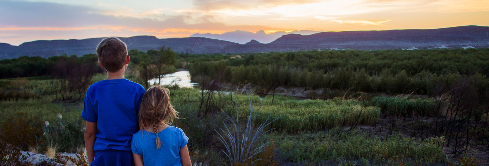 Young siblings watching the sunset.