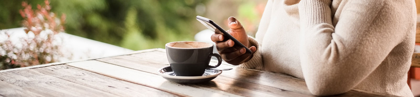 Woman drinking coffee and using her cellphone