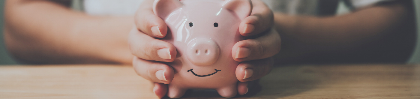 female hand holding piggy bank
