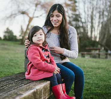 Young mother and daughter in park.