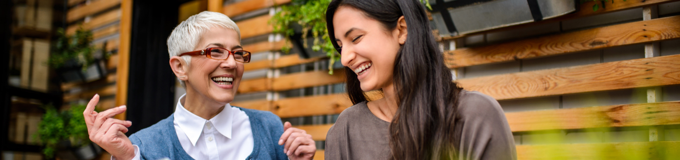 smiling older woman and smiling younger woman outside