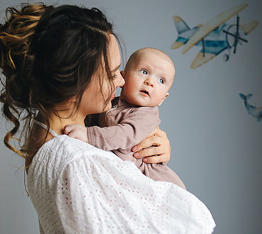 Young mom and baby in nursery.