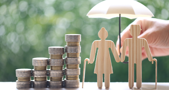 Two Wooden Figures with Stacked Coins