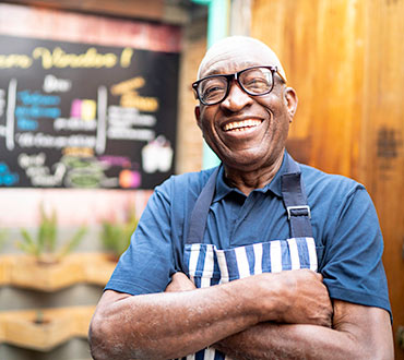 Mature man wearing apron at cafe.
